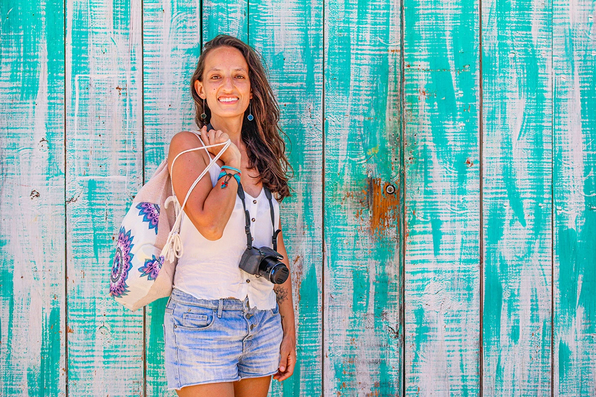 Naty Late Viaja Creadora de contenido con cámara fotográfica colgada al cuello viajando con seguro de tecnología de Intermundial