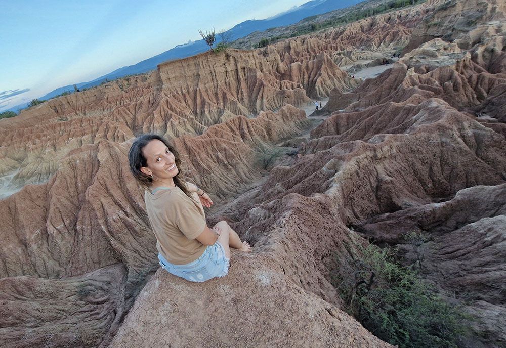 Natalia Méndez Sarmiento Viajera nómada digital sentada en un cañón desértico protegida con seguro de viaje de Intermundial