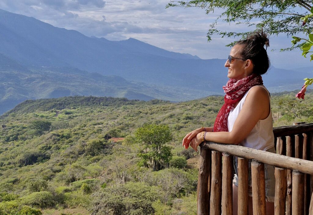 Viajera Naty Late Cuentos de Mochila contemplando un paisaje de montaña tranquila disfrutando de las coberturas del seguro Totaltravel de Intermundial